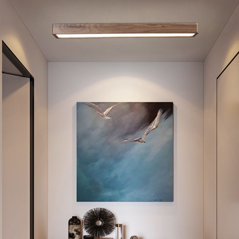 Ozawa wood-frame light above a corridor with framed artwork