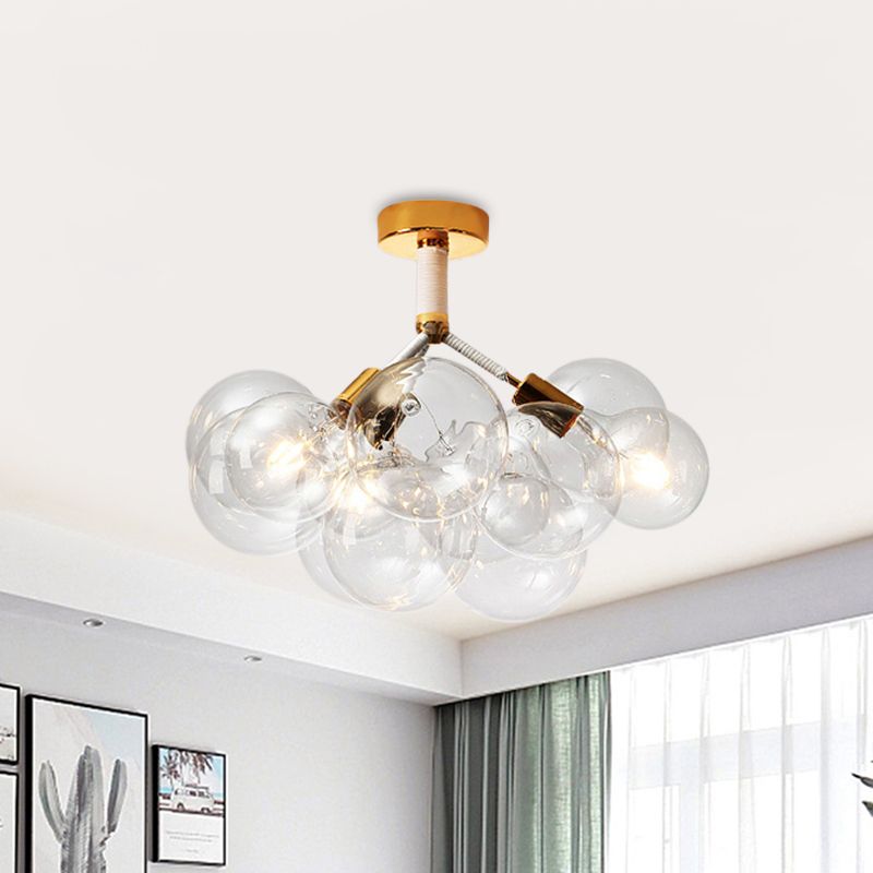 Gold-tone three-light globe cluster above a framed plant print, calendar and window