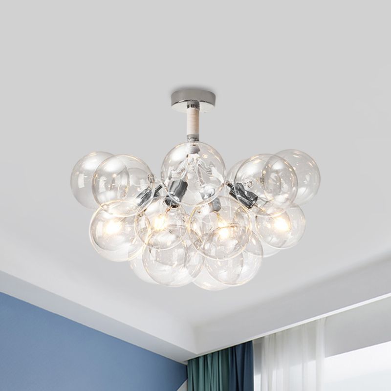Chrome four-light clear globe cluster above a blue room corner and curtains