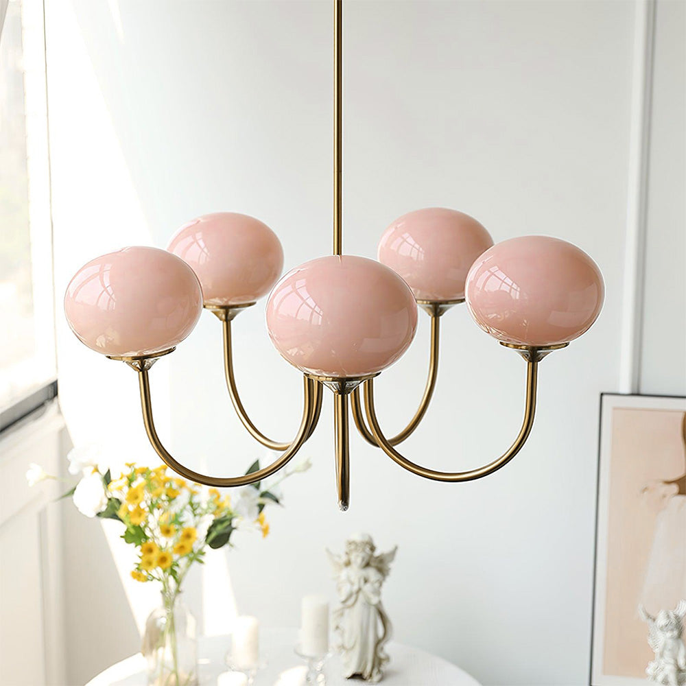 Unlit pink five-globe chandelier beside a window