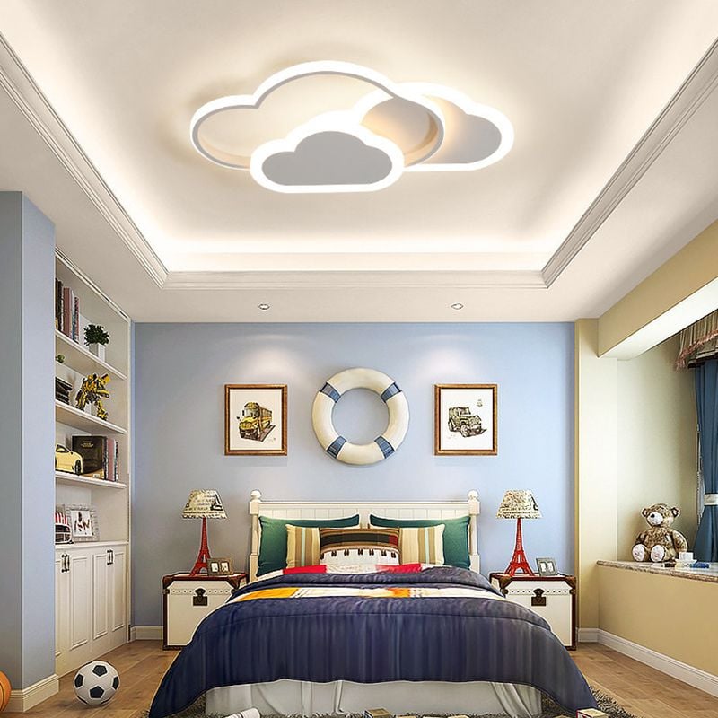 White Morandi cloud light above a bed with blue bedding.