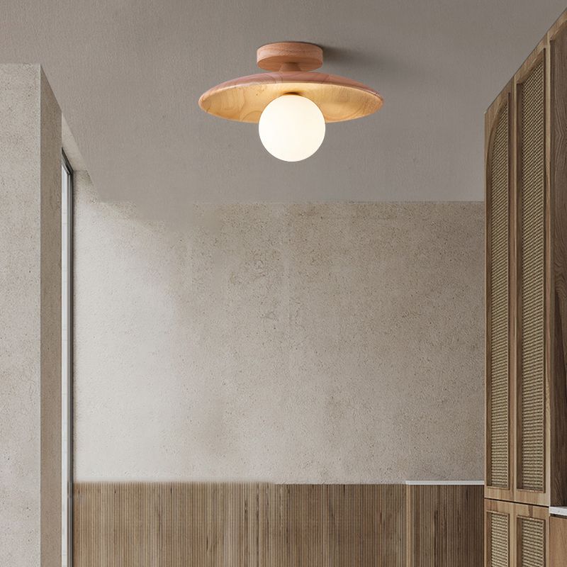 Light wood-tone Carins disc ceiling light and white globe beside a window, timber slat wall and wooden louvred cupboard doors.