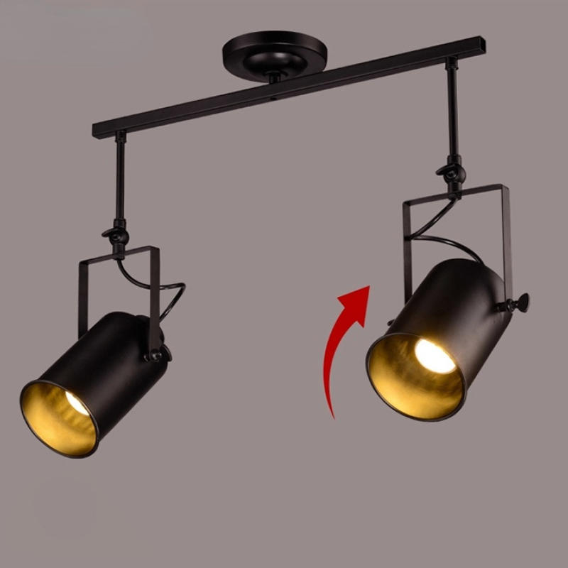 Alessio two-head black bar with lit cylindrical spotlights and a red direction arrow beside the right head.