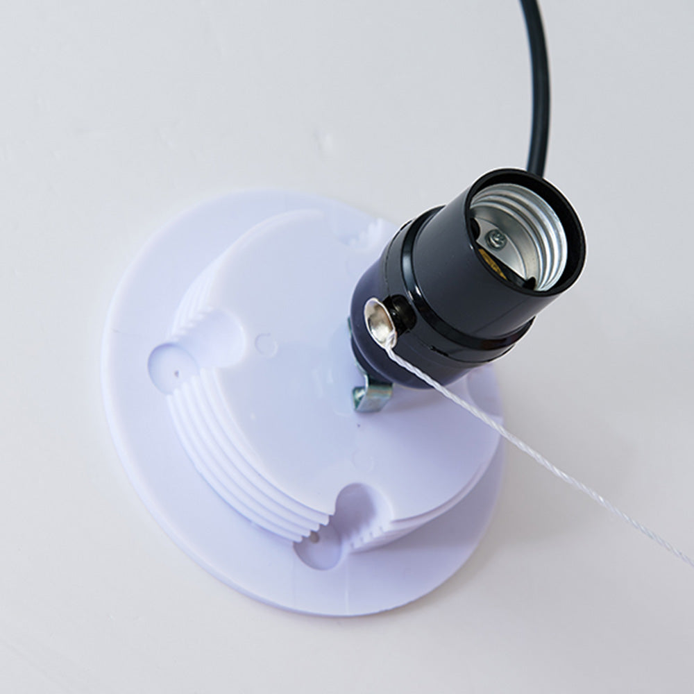 Close-up of a black threaded lamp holder on a pale round mounting plate, with a black cable and side string connection.