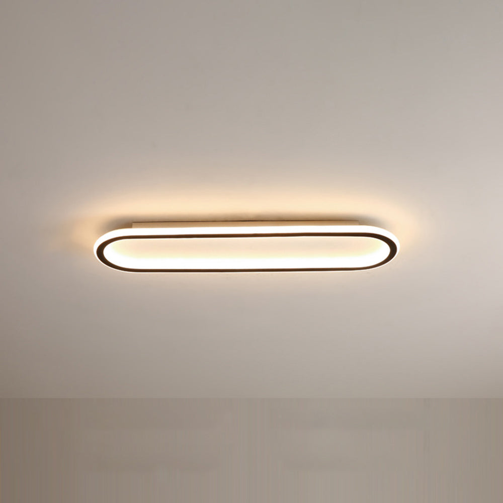 Black Quinn fixture on a plain ceiling, with pale centre and warm-looking illumination along its rounded borders.
