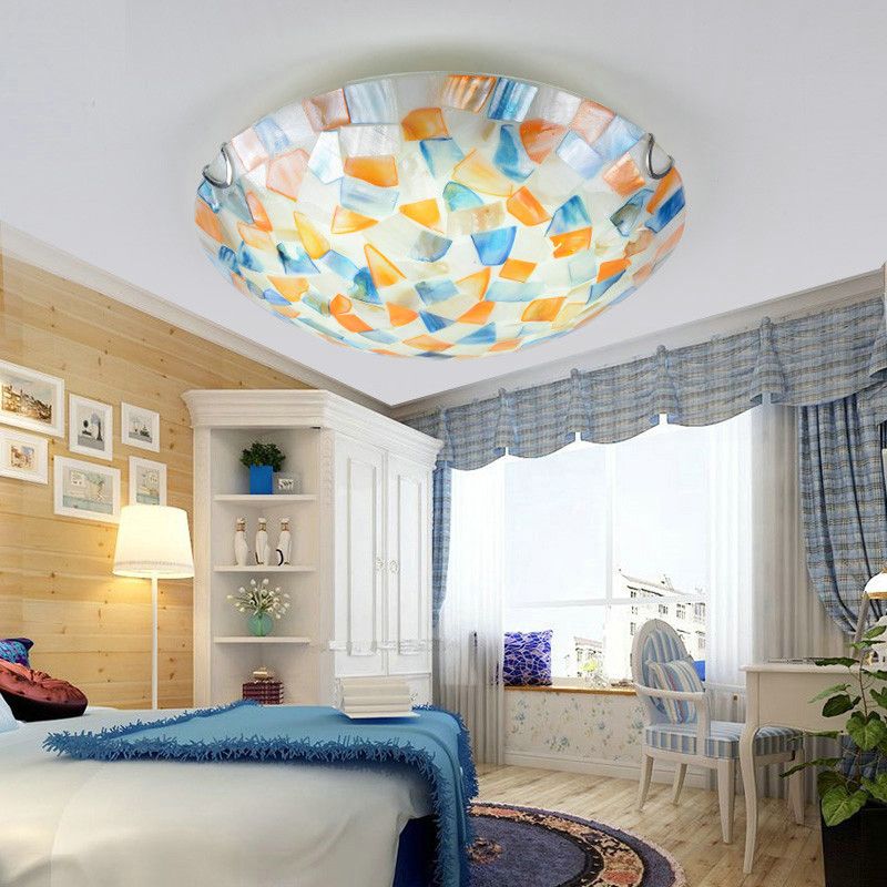 Orange and blue shell pieces in the Morandi mosaic ceiling light above a bedroom.