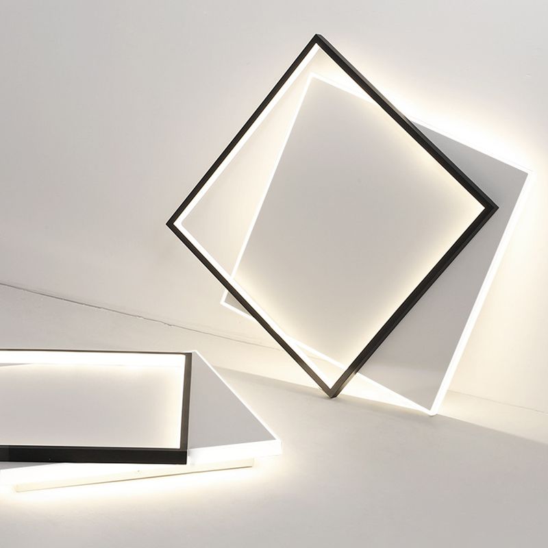Quinn black outlined square and offset white panel staged upright against a wall, with another fixture partly visible at lower left.