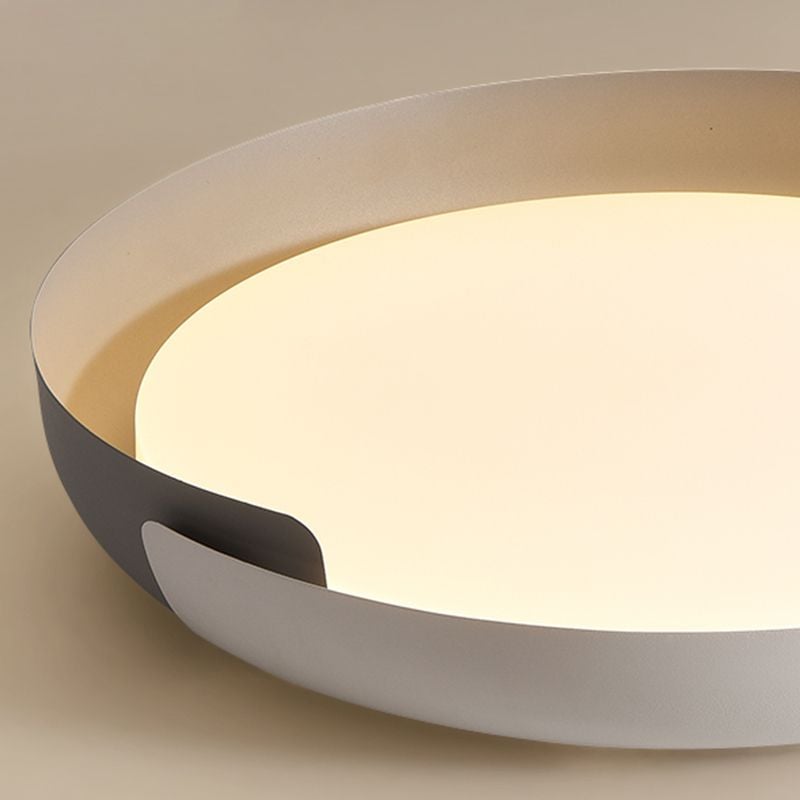 Oblique detail of a pale Quinn curved band overlapping a dark gray band around a warm-lit filled circular face.