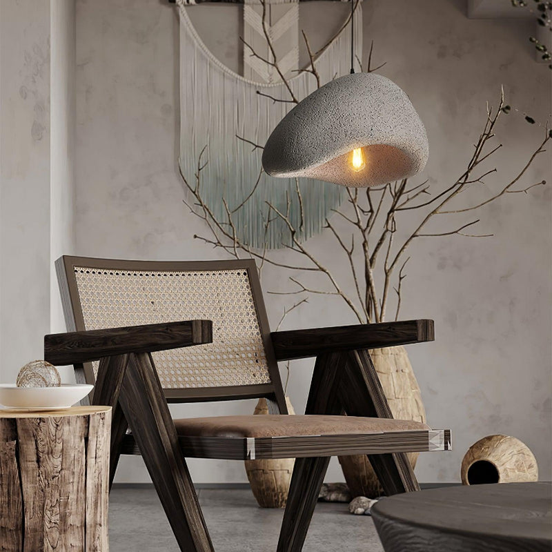 Speckled Gray cloud pendant beside a dark wooden cane chair and bare decorative branches