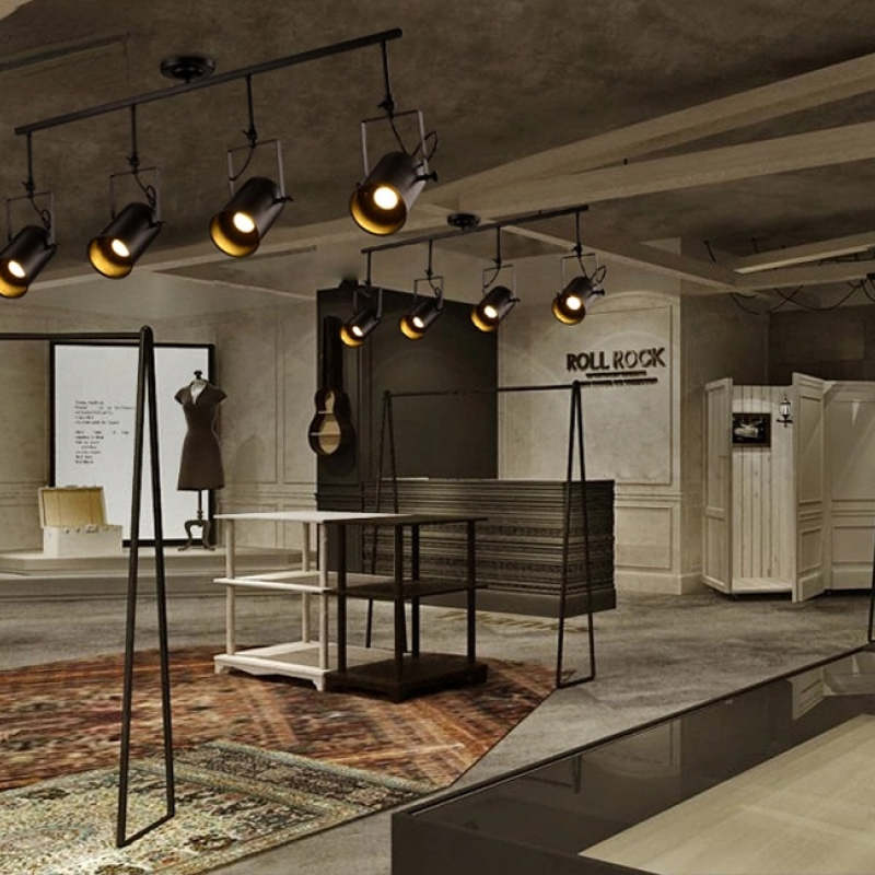 Two Alessio four-head bars above grey industrial display with mannequins, garment rails, shelving and patterned rug.