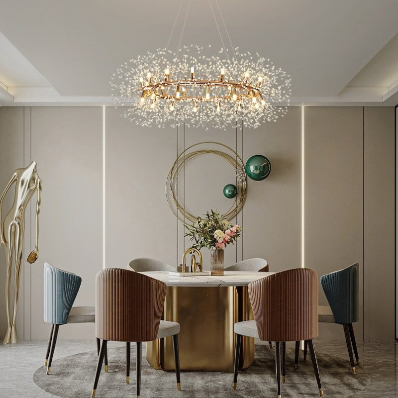 Lili crystal ring above a pale round dining table with gold-coloured base, fluted chairs, flowers and circular wall ornaments.
