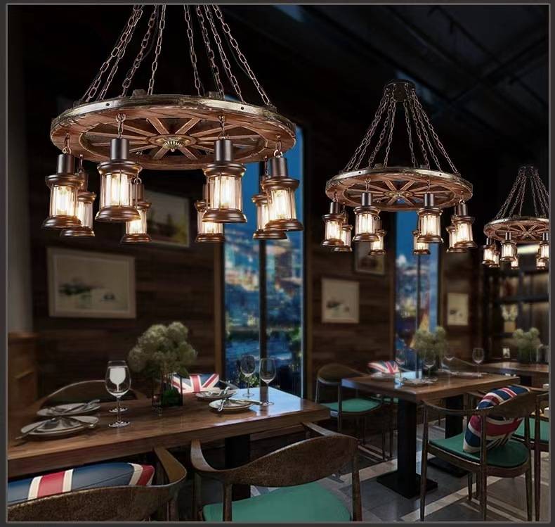 Austin wheel-and-lantern pendants above dining tables in a rustic interior.