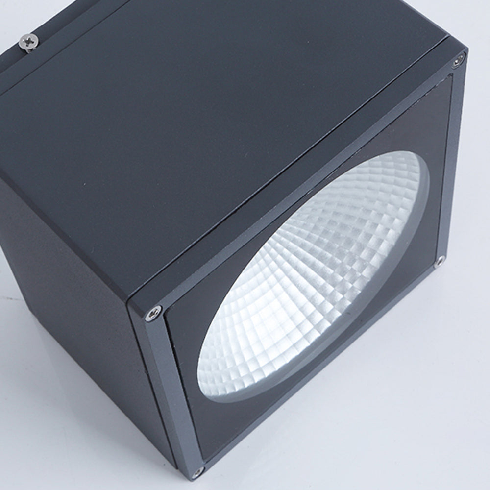 Angled Orr black square body showing side and corner screws and a broad recessed circular faceted reflector.