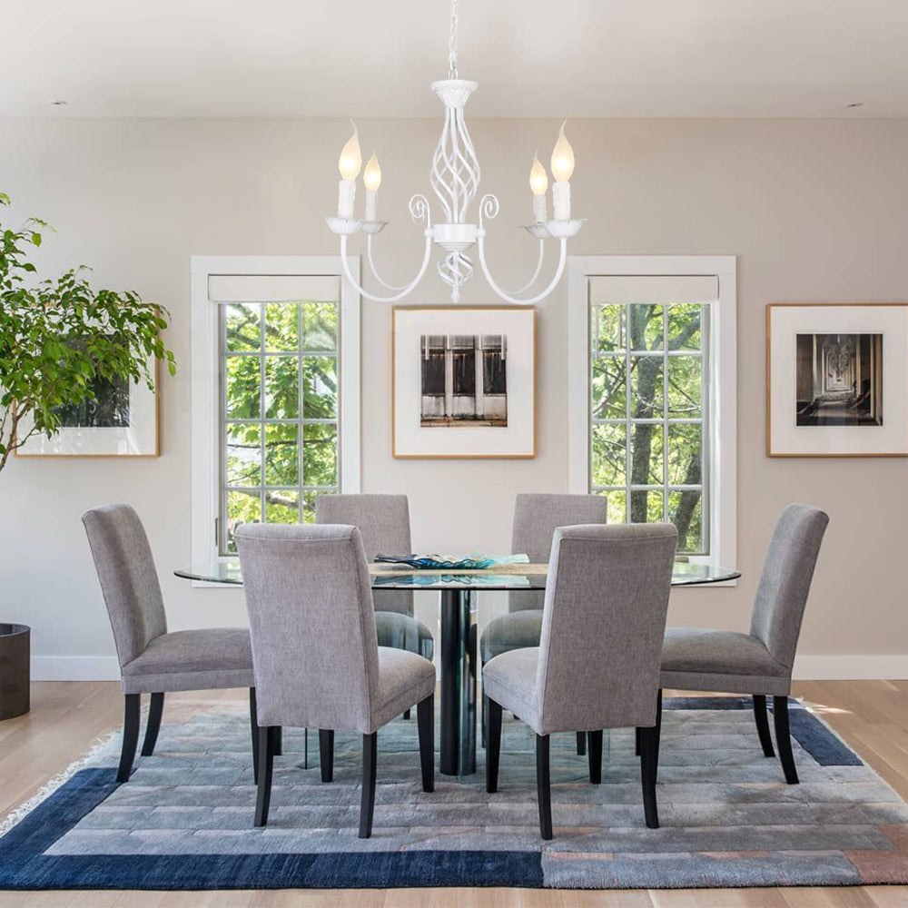 White Silva four-light chandelier above glass dining table and grey chairs, with windows and framed artwork behind