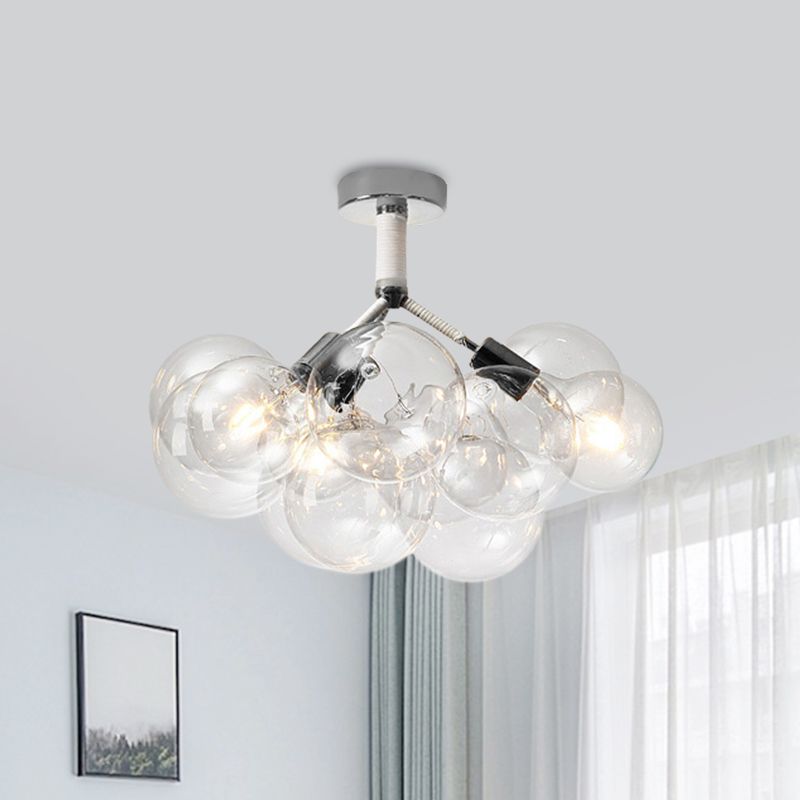 Chrome three-light clear globe cluster illuminated beside a window, curtains and framed artwork