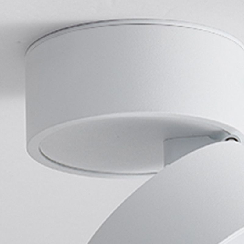 White Novak close-up of the round ceiling base, pivot and partly tilted cylindrical head.