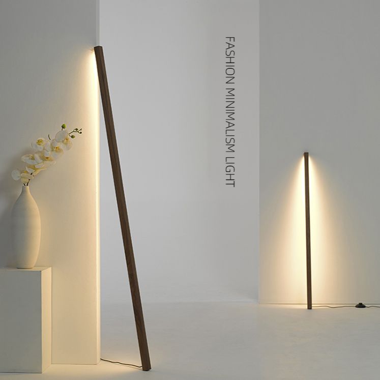 Two views of a dark wooden light bar washing a white wall with warm light beside an orchid vase on a pedestal