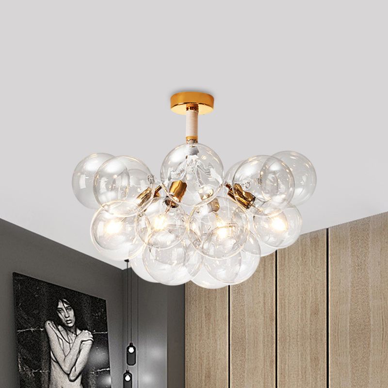 Gold-tone four-light clear globe cluster illuminated near a wardrobe and portrait