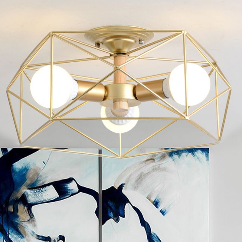 Gold three-light Cooley polygon lantern with pale wood-toned stem, above blue, black and white abstract artwork.