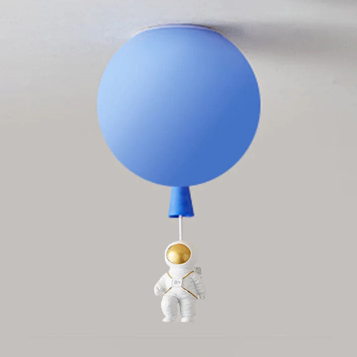 Blue balloon globe with a seated white astronaut beneath a pale link, showing lowered arms and a gold-tone visor.