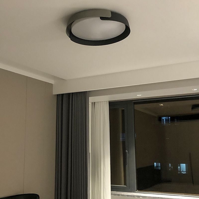 Unlit Quinn round ceiling fixture with dark and light overlapping bands beside a curtained window with night reflections.