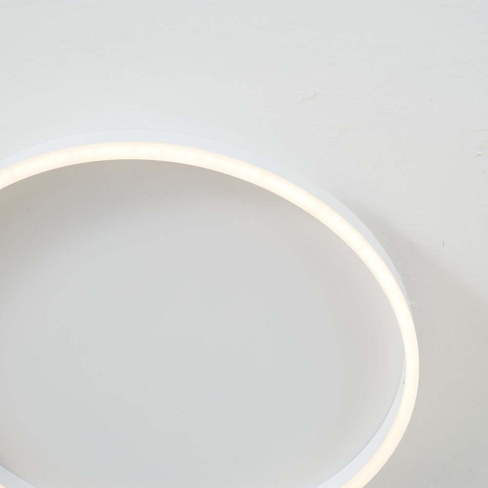 Close-up of the left arc of white Arisha against a textured ceiling, with a warm-looking strip around the underside.