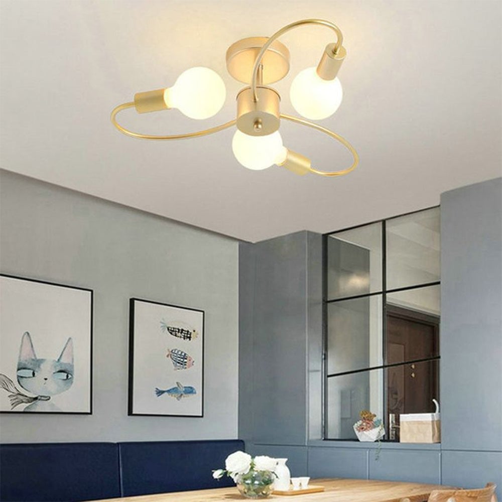 Valentina Gold three-loop light above a navy dining bench and wood table, with cat and fish artwork and a grid mirror.