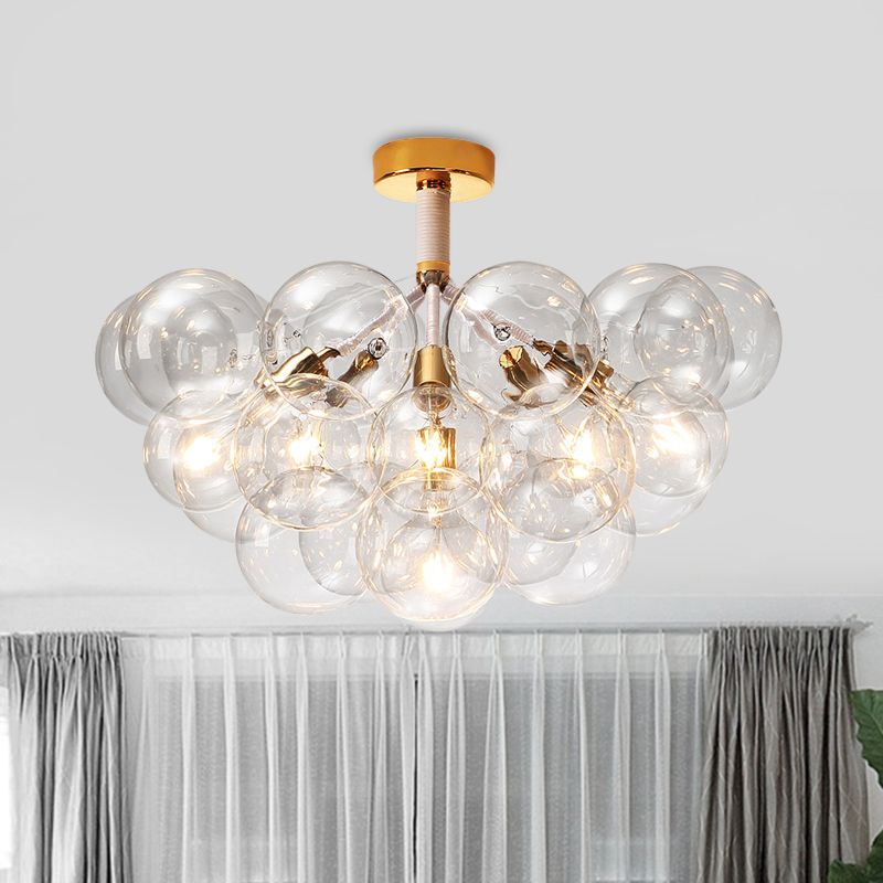 Gold-tone six-light bubble globe cluster illuminated near curtains and a green plant