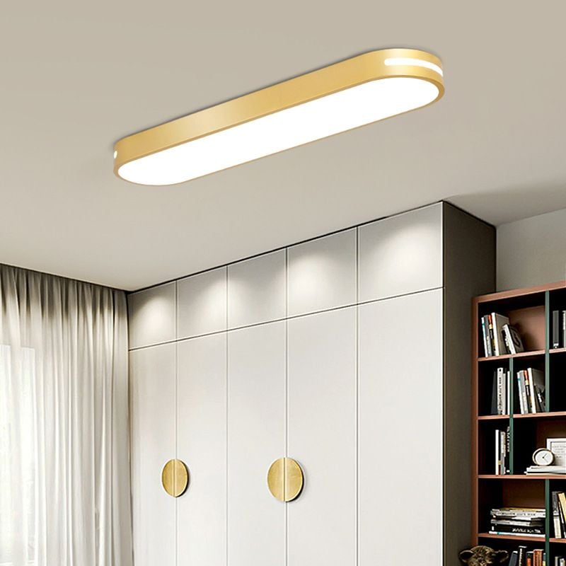 Gold Quinn ceiling fixture with a bright side slot above white wardrobe doors with round gold handles, beside curtains and a bookcase.