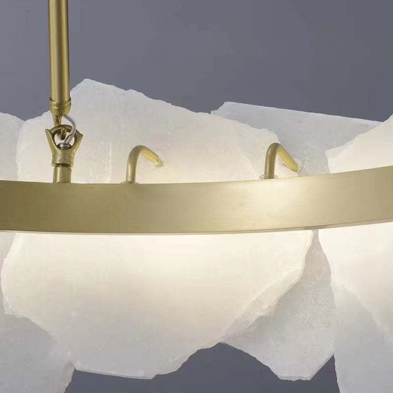 Close view of gold-colour ring and attachments behind Marilyn marble pieces