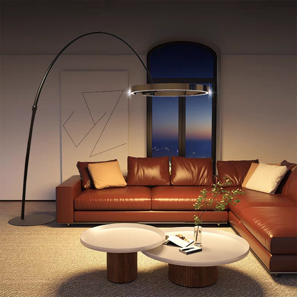 Full view of the Edge arc floor lamp beside an orange sectional sofa