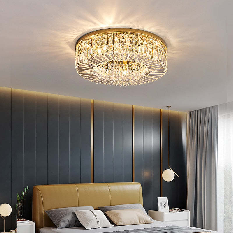 Golden Marilyn above a tan headboard and gray bedding, with dark blue wall panels, thin gold accents and separate globe lights.