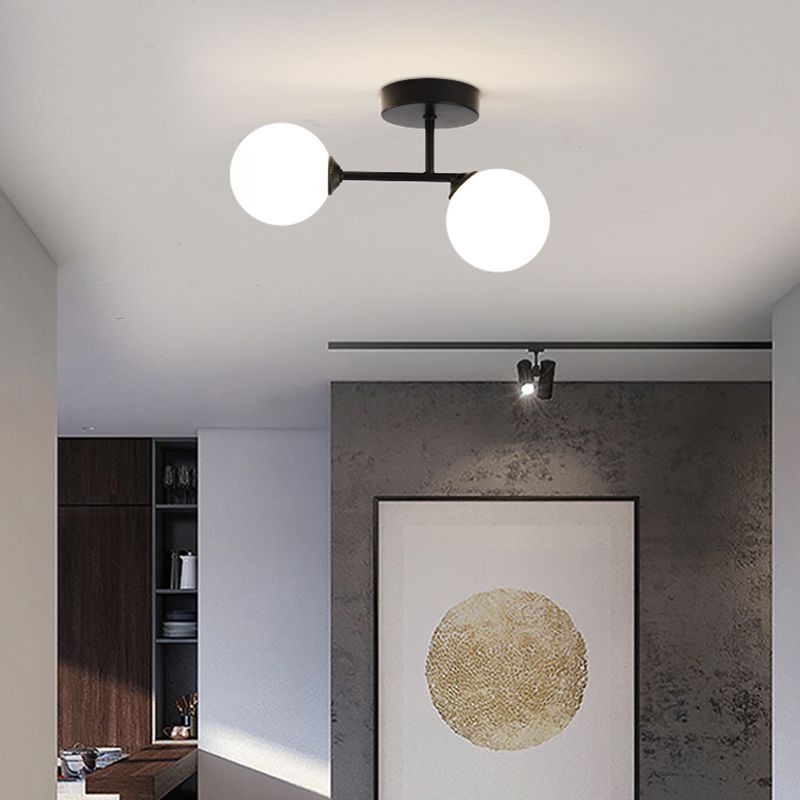 Black Valentina in a room with gold-circle wall art, dark cabinetry and a separate ceiling track spotlight.