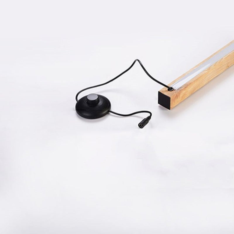 Close-up of the wooden bar end with black cable, round floor control and barrel connector