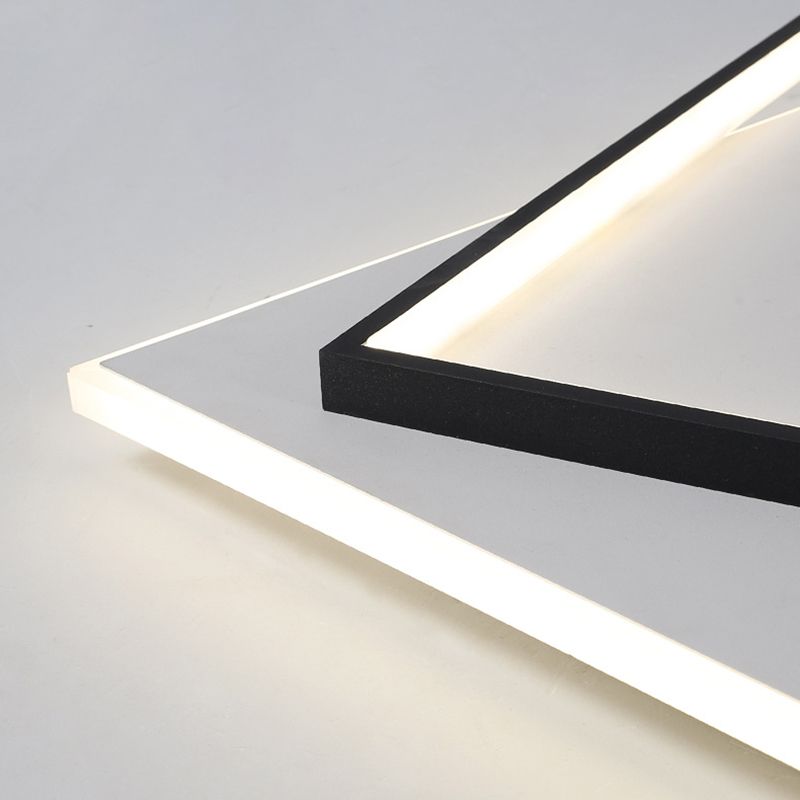 Close-up of a black Quinn frame corner crossing the edge of the white square panel, with luminous strips and fine surface texture.