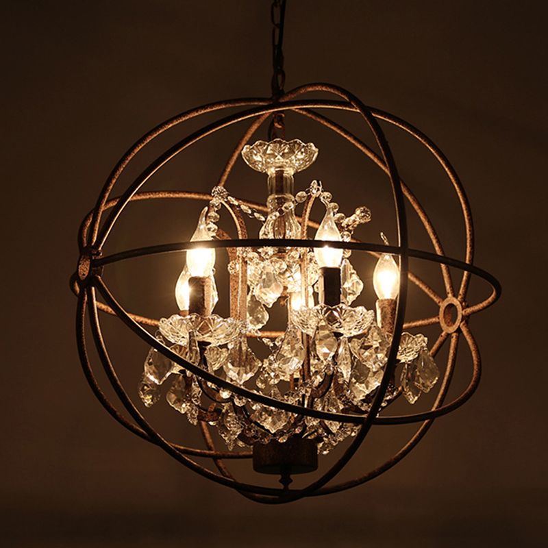 Close view of the lit candle-style bulbs and crystal drops inside the Kristy metal cage.