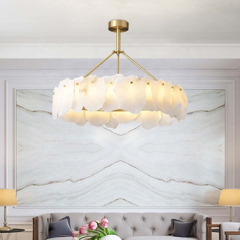 Lit Marilyn marble ring pendant above a sofa and pale stone wall