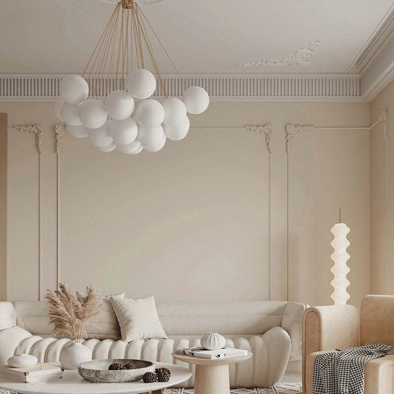 White globes and gold suspension above a sofa