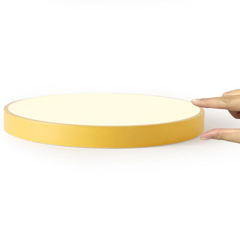 Yellow Morandi ceiling light viewed from the side on white, with a hand indicating the shallow rim beside its pale circular shade.