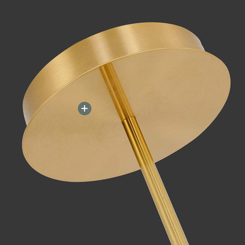 Louise close-up of a round gold-tone canopy and rod connection with a brushed-looking surface, against a dark background.