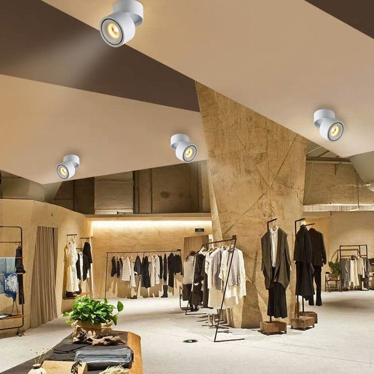 White Novak ceiling spotlights illuminating a clothing-store interior.