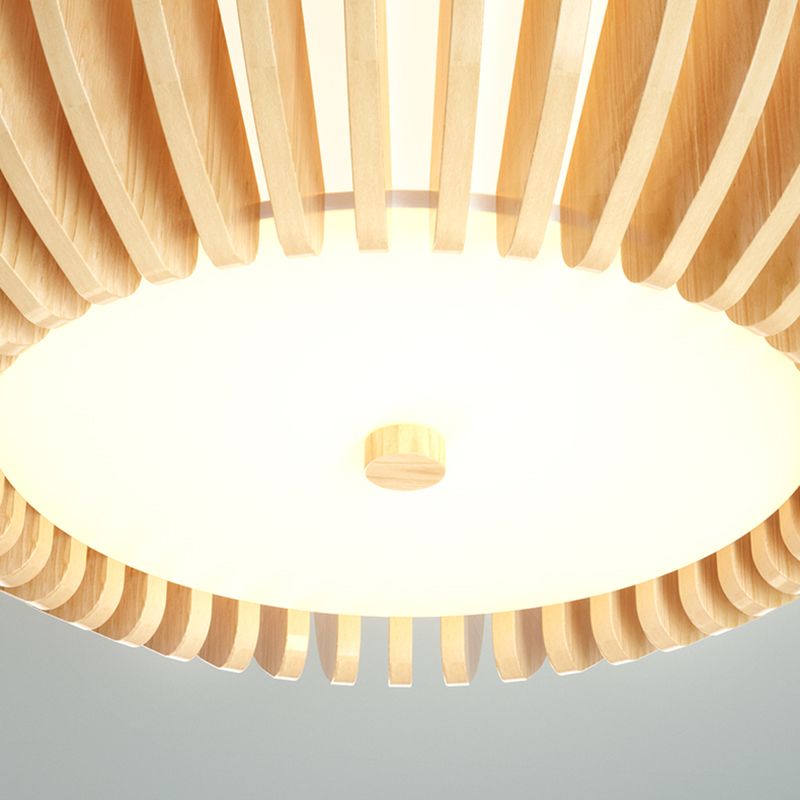 Underside of lit Ozawa showing a broad circular light face and small wood-tone centre cap surrounded by curved slats.