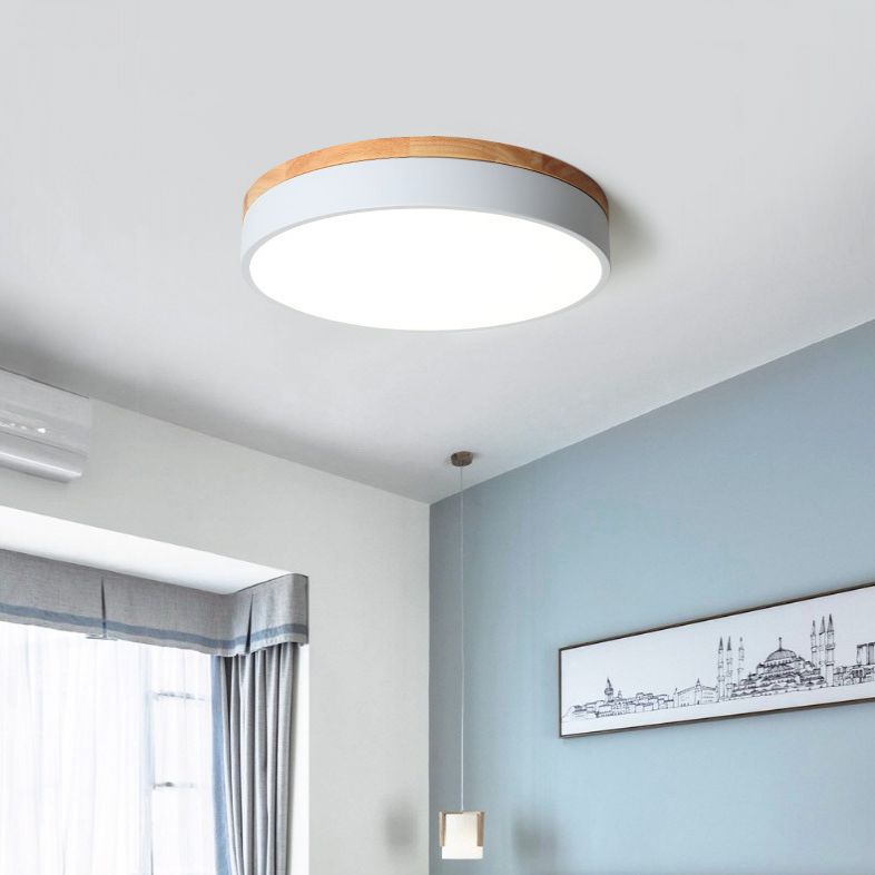 White Morandi ceiling light beside a pale blue wall, framed architectural drawing and window curtains.