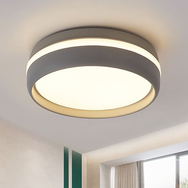 Grey round ceiling light with a warm-looking glow above a window and green wall panel