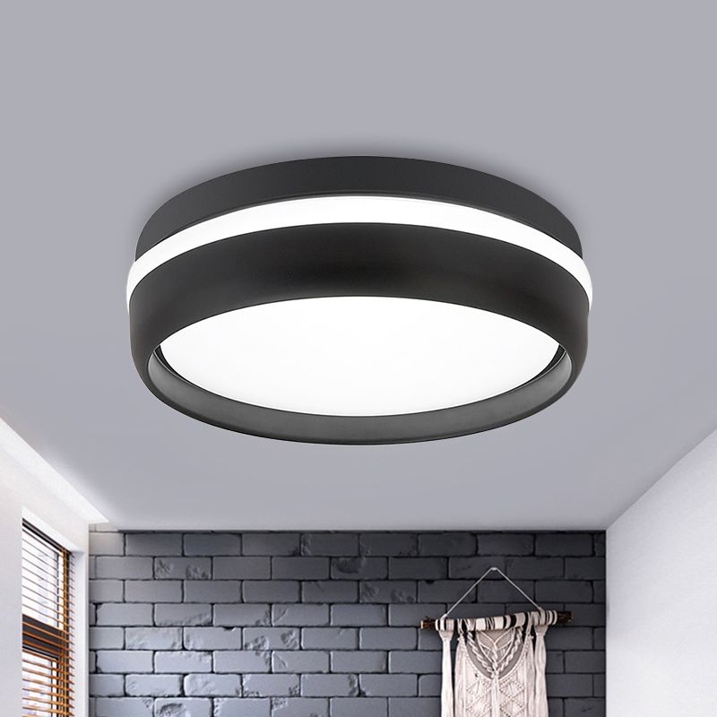 Black round ceiling light above a brick-pattern wall and hanging textile, with lit circular panel and side band
