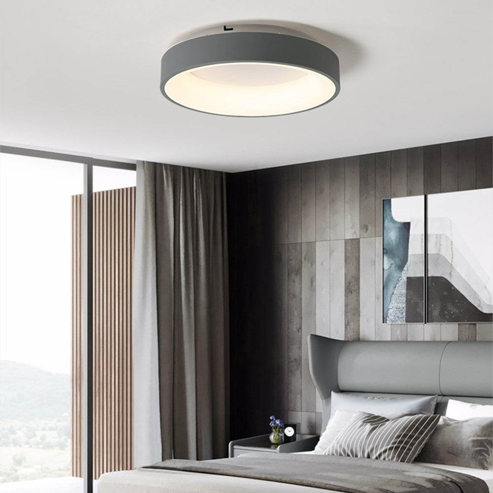 Grey Quinn ceiling light above grey winged upholstered bed, striped pillows, abstract two-panel artwork and grey curtains.