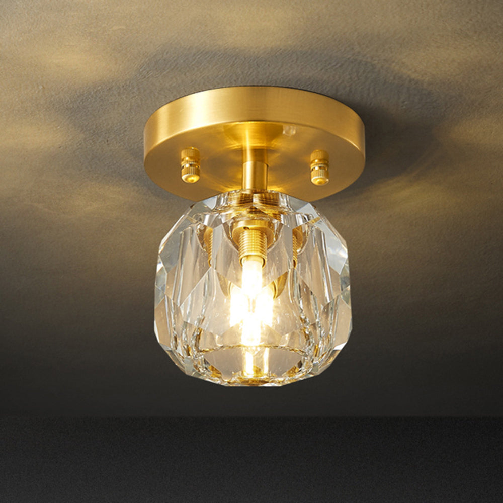 Lit Kirsten fixture against a textured grey ceiling, with gold-tone round canopy, short stem and clear rounded facets.