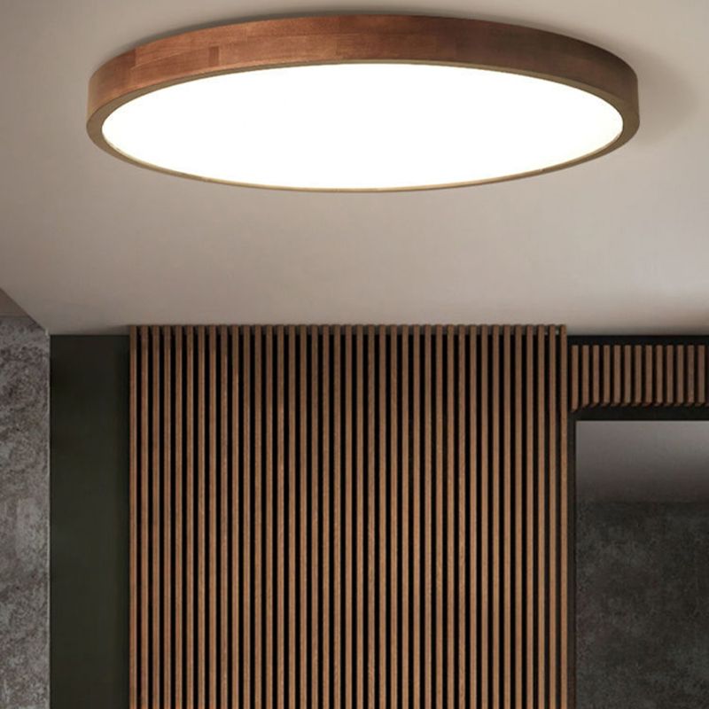 Round Ozawa ceiling light near a wood-slat wall, a dark framed picture and a grey stone-pattern wall.