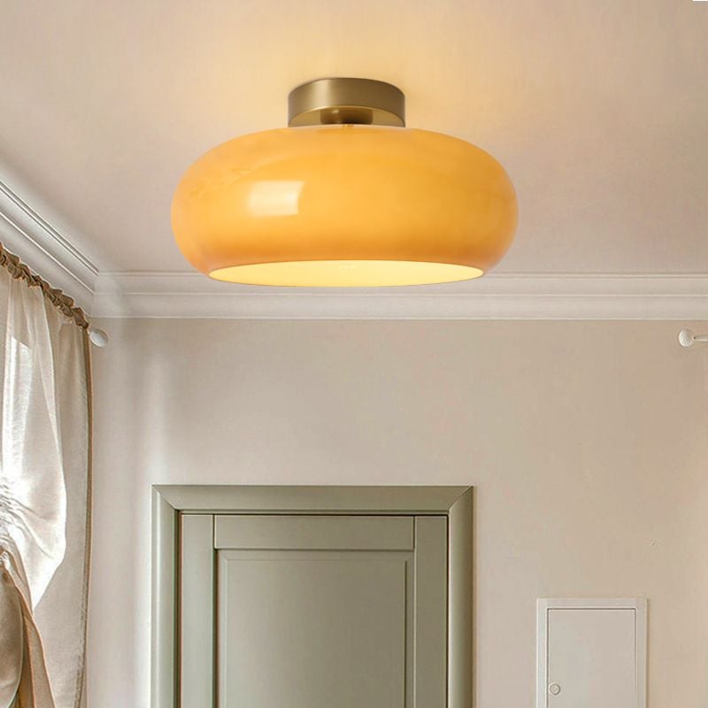 Orange close-mounted Hailie dome light above a pale room