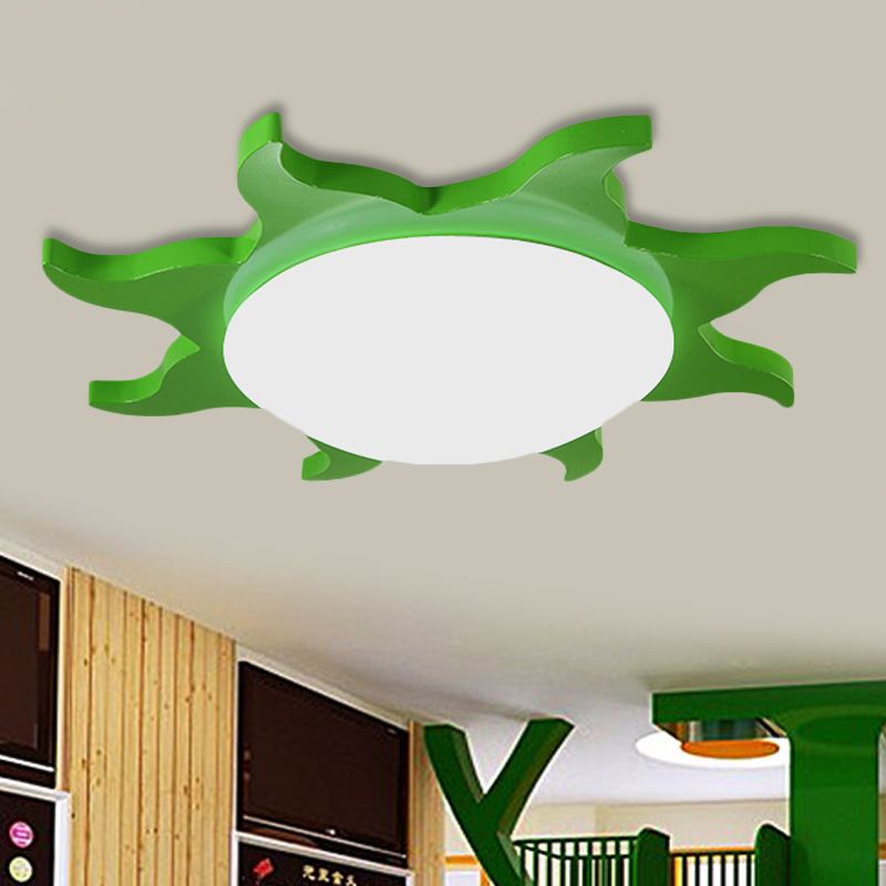 Green Freja sun ceiling light above a room with tree-shaped decor
